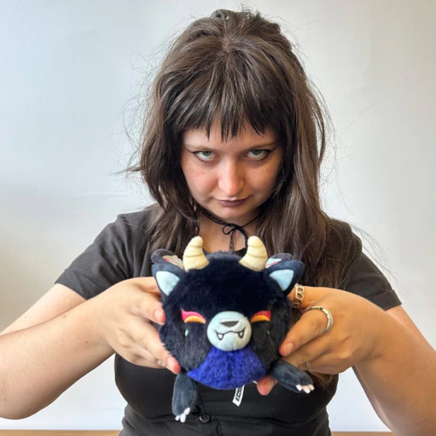 person holding Demon Kitsune plush with nine tails and playful expression