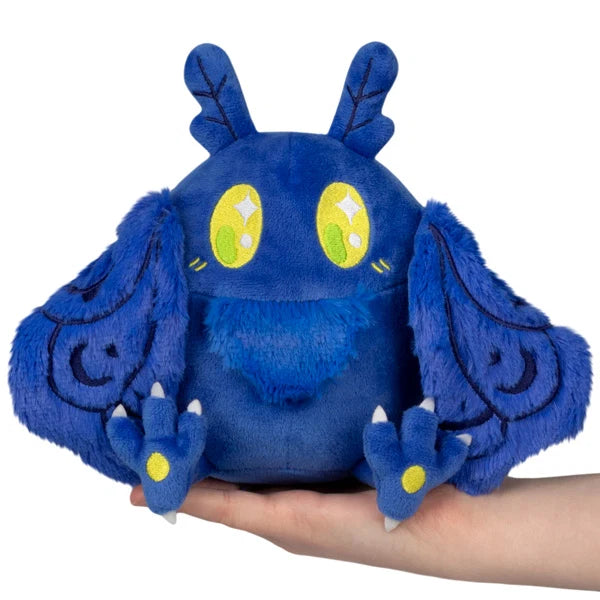 Squishable Snacker Blue Mothman S1E3 limited edition plush featuring deep blue fur, embroidered wings, and bright yellow eyes.