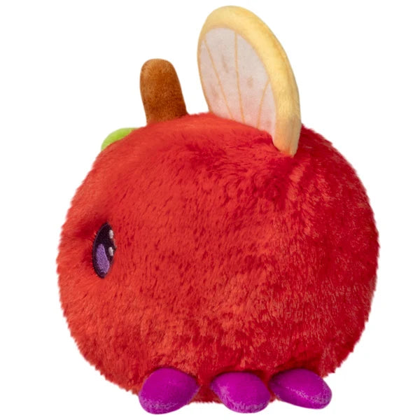 Squishable Snacker Fruit Fly S1E3 limited edition plush shaped like a red apple with citrus slice wings and purple feet.