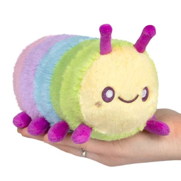 Squishable Snacker Rainbow Caterpillar S1E5 Limited Edition plush with pastel rainbow segments, magenta antennae, and small legs.