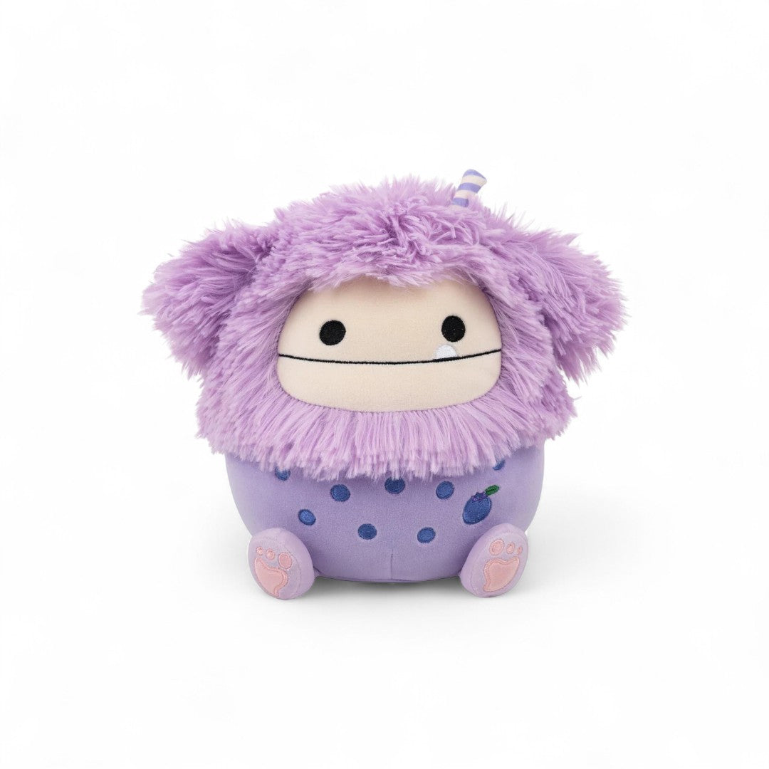 Purple plush toy with a fluffy top and polka dot body on a white background