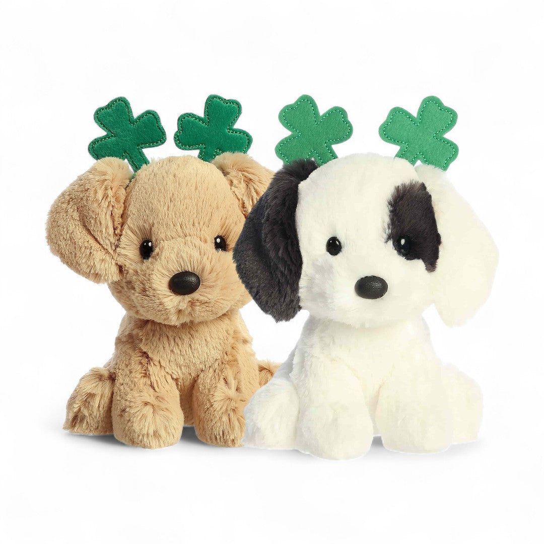 Two plush dogs with green clover leaf accessories on a white background
