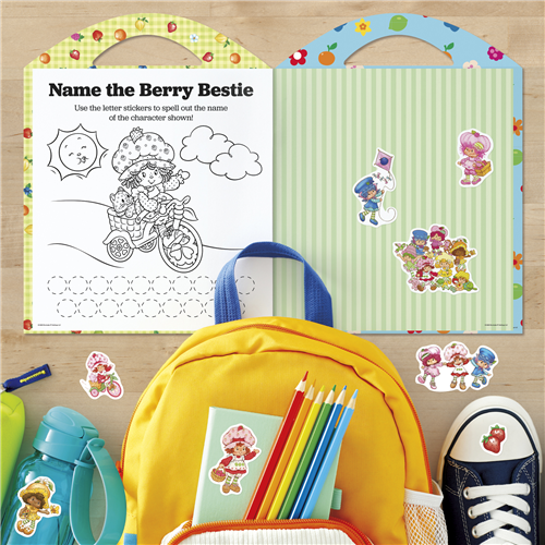 Coloring book with stickers and school supplies on a wooden surface