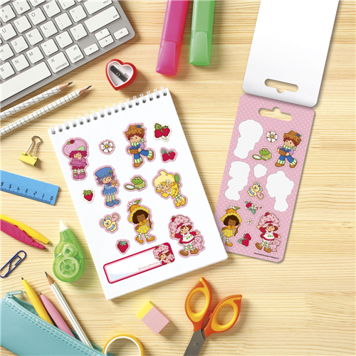 Sticker sheet with cartoon characters on a desk with stationery items