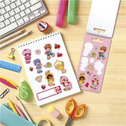 Sticker sheet with cartoon characters on a desk with stationery items