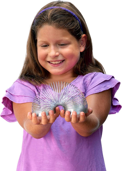 A girl holding The Original Slinky, a metal walking spring toy, shown both in its classic red box and arched in a semi-circle on a white background.