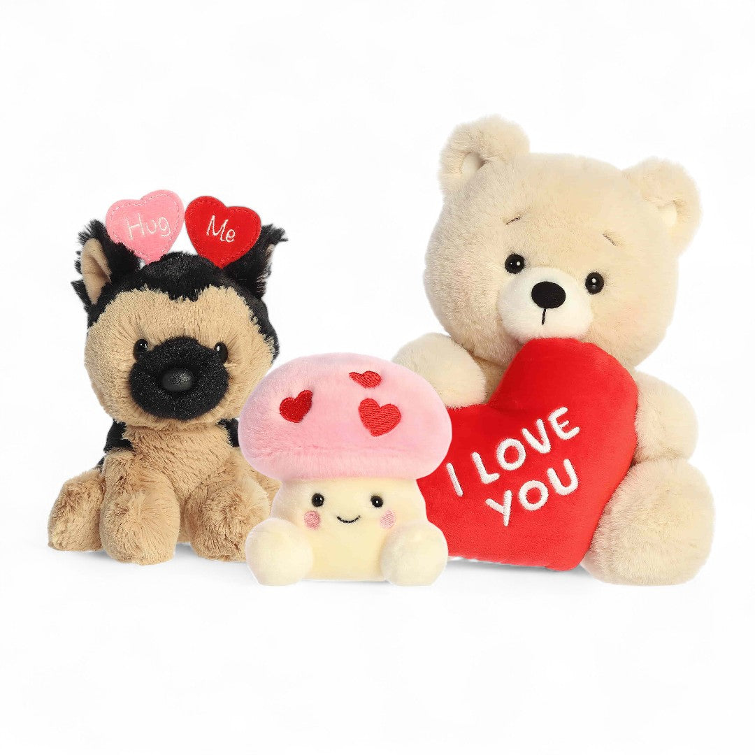 Three plush toys including a dog, bear, mushroom, and heart-shaped 'I Love You' pillow on a white background.