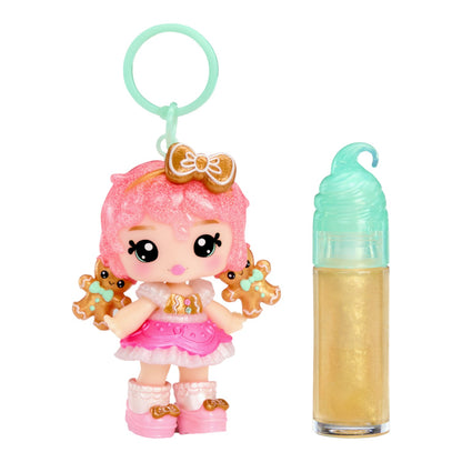 Yummiland Gigi Gingerbread Holiday Lip Gloss Doll with DIY Kit with pink hair and gingerbread theme next to a small bottle on a white background