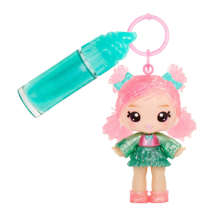 Toy figure with pink hair and green outfit next to a teal bottle on a white background